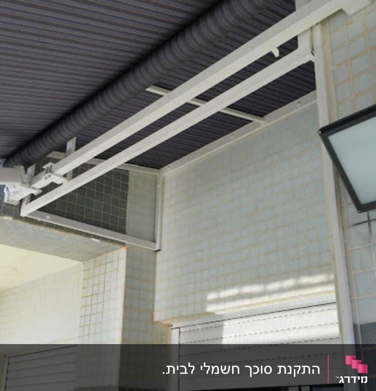 סוכך בד מפוספס מותקן על קיר חיצוני